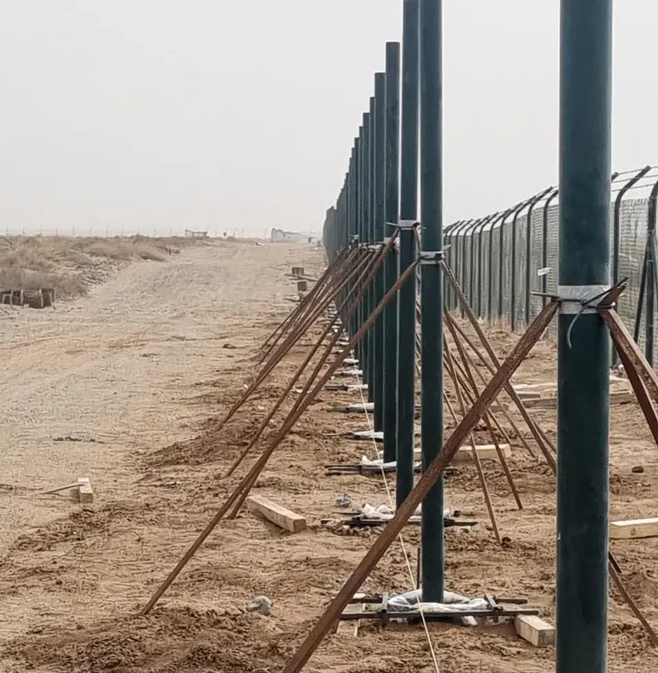 Row of braced fence posts across the desert